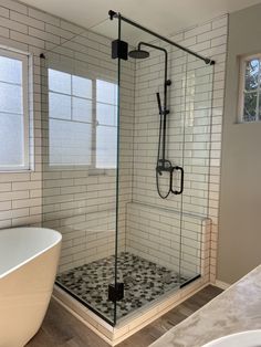 a white bath tub sitting next to a walk in shower