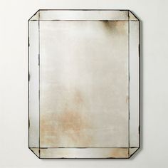 a square mirror mounted on the wall