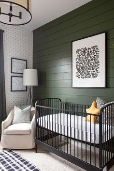 a baby's room with green painted walls and a white crib in the corner