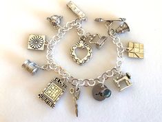 "Adorable quilting charm bracelet featuring detailed 3D pewter quilting charms and personalized initial and Swarovski birthstone on silver bracelet with toggle clasp. Ten beautifully detailed quilting charms are all 3D/two-sided pewter made in USA and lead and nickel free. Included are: thimble with heart, friendship star quilting block, Singer sewing machine, scissors, \"I Love Quilting\" block, spool of thread with needle, Dresden flower block, pin cushion, tape measure, and iron. Hand stamped Silver Bracelet Jewelry For Gift Making, Personalized Silver Charm Bracelet For Gift Making, Personalized Silver Jewelry With Dangling Charms, Vintage Silver Jewelry For Gift Making, Silver Jewelry With Dangling Charms For Personalized Gift, Spool Of Thread, Quilter Gifts, Iron Hand, Personalized Quilt