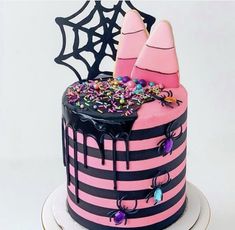 a pink and black striped cake with sprinkles