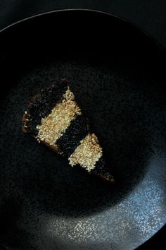 a piece of cake sitting on top of a black plate