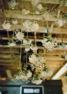 white flowers are hanging from the ceiling in front of an old television set and sound board