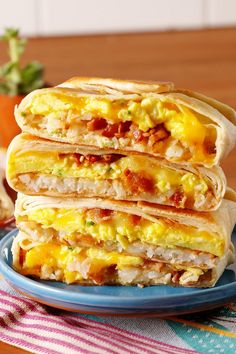 a stack of breakfast burritos sitting on top of a blue plate