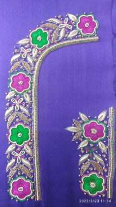 an embroidered piece with flowers and leaves on purple fabric, in front of a blue background