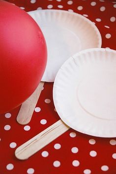 paper plates and balloons on a red table cloth