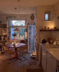 a kitchen filled with lots of furniture next to a dining room table and chairs in front of a window