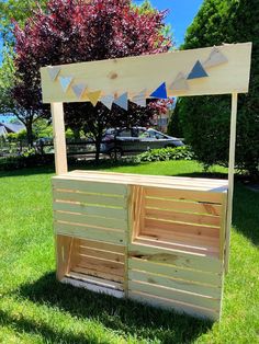 an outdoor bar made out of pallet wood in the grass with bunting flags