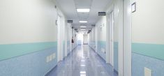 an empty hospital hallway with blue and white walls