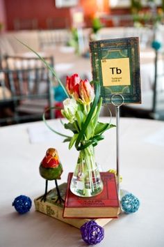 a vase filled with flowers sitting on top of a table next to small birds figurines