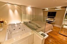 a bedroom with a large jacuzzi tub in the middle and wooden flooring