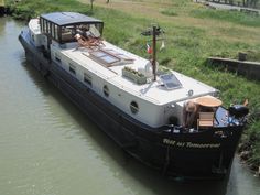 a boat is docked in the water near some grass