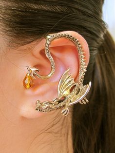 Take your place in the spotlight wearing this dramatic, sterling silver Throne Dragon Ear Wrap with a Swarovski Briolette suspended from the tip of the tail. This graceful and powerful dragon is completely three dimentional and curves gracefully down and along the left ear. The Throne Dragon Ear Wrap is 2" long and configured for the left ear only. Please choose the Swarovski Briolette from the following color options.Our ear wraps require no piercings. Ear wraps have a sturdy wire that wraps be Dragon Ear Cuffs, Elf Ear Cuff, Ear Cuff Jewelry, Dragon Earrings, Gra O Tron, Dragon Jewelry, Ear Cuff Earings, Style Punk, Ear Cuffs