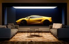 a yellow sports car is on display in a room with two couches and a coffee table