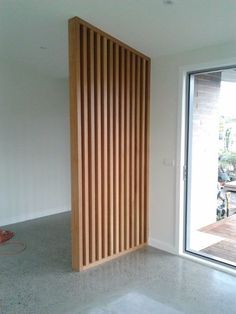 an empty room with a sliding glass door and wooden slats on the wall behind it