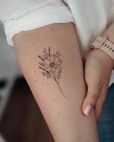 a woman's arm with a flower tattoo on the left side of her body