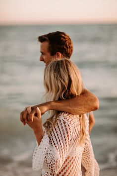 a man carrying a woman on his back at the beach