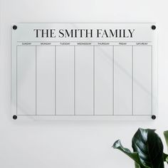 a white board with the words the smith family on it next to a potted plant