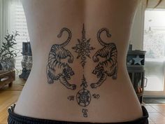 a woman's back with tattoos on her body and two tigers in the middle