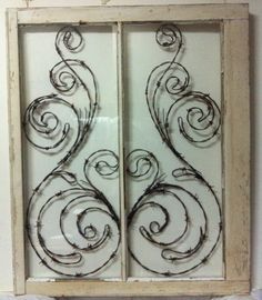 an old window is decorated with wrought iron designs on the glass and wood frame,