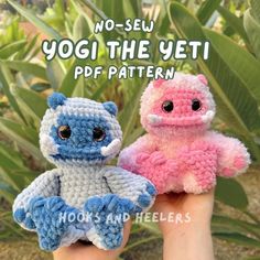 two small crocheted stuffed animals sitting next to each other in front of plants