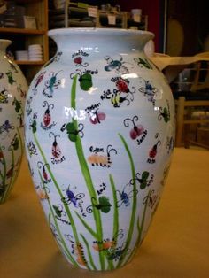 two white vases with colorful designs on them