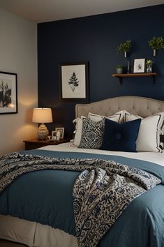 a bedroom with blue walls and white bedding, two framed pictures on the wall