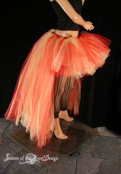 a woman in a black top and orange tulle skirt