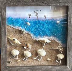 three seashells are walking on the beach in front of an ocean scene made out of sand