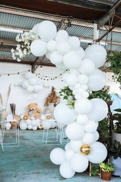 white balloons are hanging from the ceiling in a room