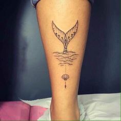 a woman's leg with a tattoo on it that has a whale tail in the water