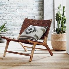 a chair sitting on top of a wooden floor next to a potted plant