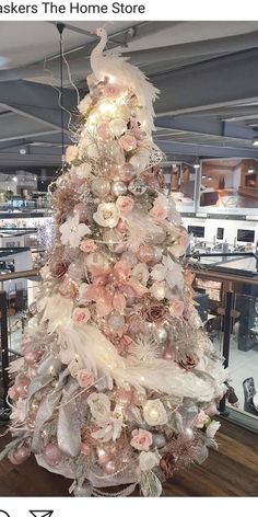 a white christmas tree decorated with pink and silver ornaments