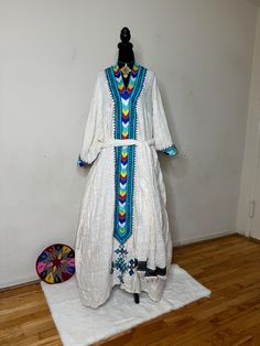 Ethiopian and Eritrean traditional dress, habesh kemis, beautiful,simple,featuring intricate embroidery with vibrant colors. The design suggests it might be from a specific cultural or ethnic background. The dress has a prominent V-shaped neckline with multicolored geometric            100%cotton Ethnic Background, Dress Simple, Intricate Embroidery, Traditional Dress, Silver Spring, Dress Clothes For Women, Traditional Dresses, V Shape, The Dress