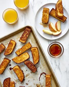 slices of toasted bread on a baking sheet next to glasses of orange juice