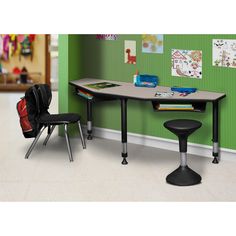 a desk and chair in a room with green walls