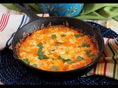 a skillet filled with food sitting on top of a blue and white table cloth