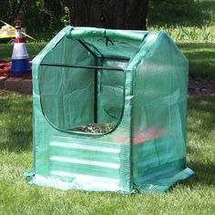 a small green house sitting in the grass