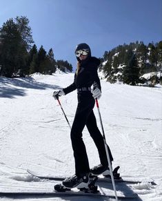 a woman on skis in the snow with trees in the backgrouund