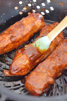 two pieces of meat being cooked in a frying pan