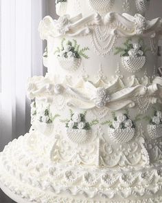 a large white wedding cake with flowers on it