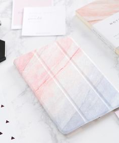 a white table topped with notebooks and other items next to each other on top of a marble surface