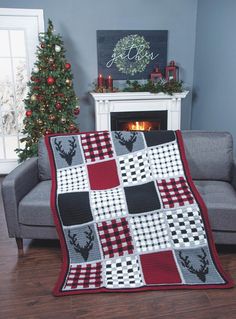 a living room with a couch, christmas tree and fire place in the fireplace area