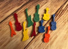 colorful wooden pegs are arranged in the shape of musical instruments on a wood surface