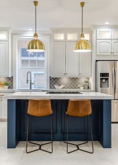 a kitchen with two stools next to an island