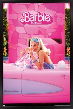 a woman in a pink car with the word barbie on it's back and behind her