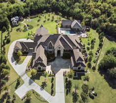 an aerial view of a large house with lots of trees and grass in the foreground