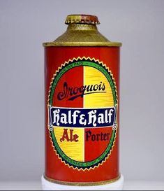 a red and yellow beer can sitting on top of a table