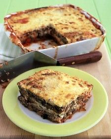 a piece of lasagna sitting on top of a green plate next to a knife