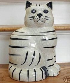 a ceramic cat sitting on top of a wooden table